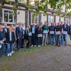 Landrat Dr. Jens Mischak (vorne, Fünfter von links), Vorstandsvorsitzender des Vereins Region Vogelsberg, und Edwin Schneider (Zweiter von links), Vorsitzender des LEADER-Beirats, gemeinsam mit Vertreterinnen und Vertretern der Vereine und Kommunen sowie des LEADER-Regionalmanagements bei der Übergabe der Zuwendungsverträge am Herbsteiner STATT-Museum.