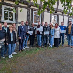 Landrat Dr. Jens Mischak (vorne, Fünfter von links), Vorstandsvorsitzender des Vereins Region Vogelsberg, und Edwin Schneider (Zweiter von links), Vorsitzender des LEADER-Beirats, gemeinsam mit Vertreterinnen und Vertretern der Vereine und Kommunen sowie des LEADER-Regionalmanagements bei der Übergabe der Zuwendungsverträge am Herbsteiner STATT-Museum. (Foto: Vogelsbergkreis/C.Lips)