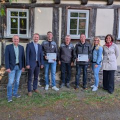 Landrat Dr. Jens Mischak (vorne, Fünfter von links), Vorstandsvorsitzender des Vereins Region Vogelsberg, und Edwin Schneider (Zweiter von links), Vorsitzender des LEADER-Beirats, gemeinsam mit Vertreterinnen und Vertretern der Vereine und Kommunen sowie des LEADER-Regionalmanagements bei der Übergabe der Zuwendungsverträge am Herbsteiner STATT-Museum.