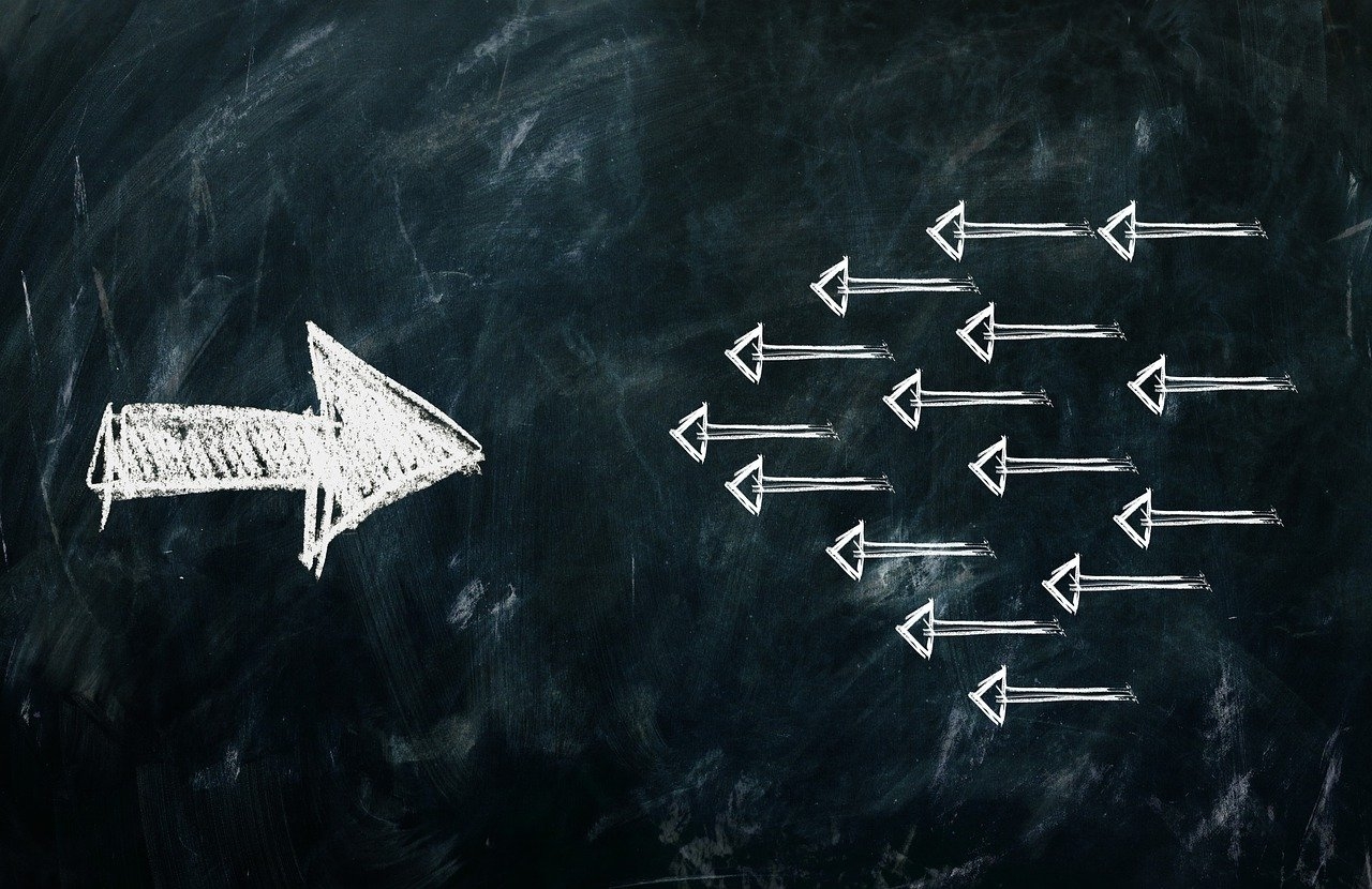 Kleine Pfeile, die nach links weisen, und ein großer Pfeil, der entgegengesetzt nach rechts weist, stehen symbolisch für Resilienz und Widerstandskraft