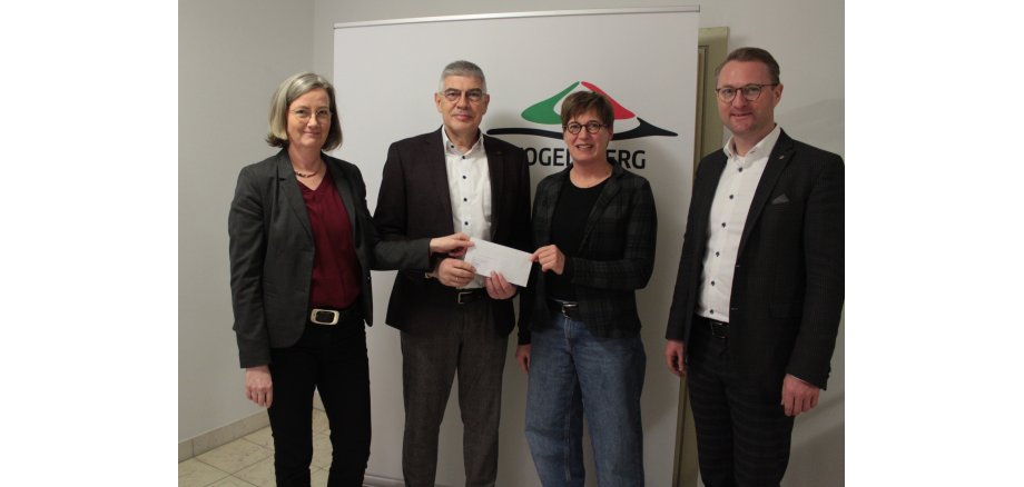 Landrat Manfred Görig übergibt dem Verein „Kulturförderung Vogelsberg“ – hier vertreten durch den Vorsitzenden Dr. Jens Mischak (rechts) sowie Barbara Brod (Mitte) und Andrea Ortstadt von der Kulturförderung Vogelsberg - die Zuwendung für den Vulkansommer 2023. 