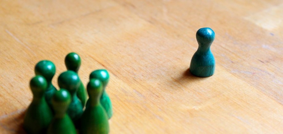 Einige kleine Spielfiguren stehen auf einem Holztisch.