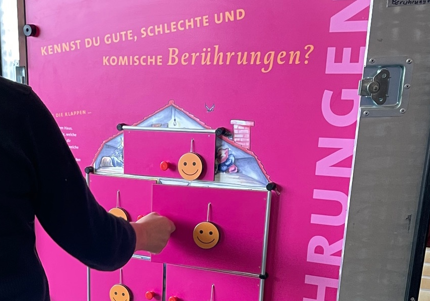 Eine Person bedient eine interaktive Informationstafel zu sexuellem Missbrauch von Kindern