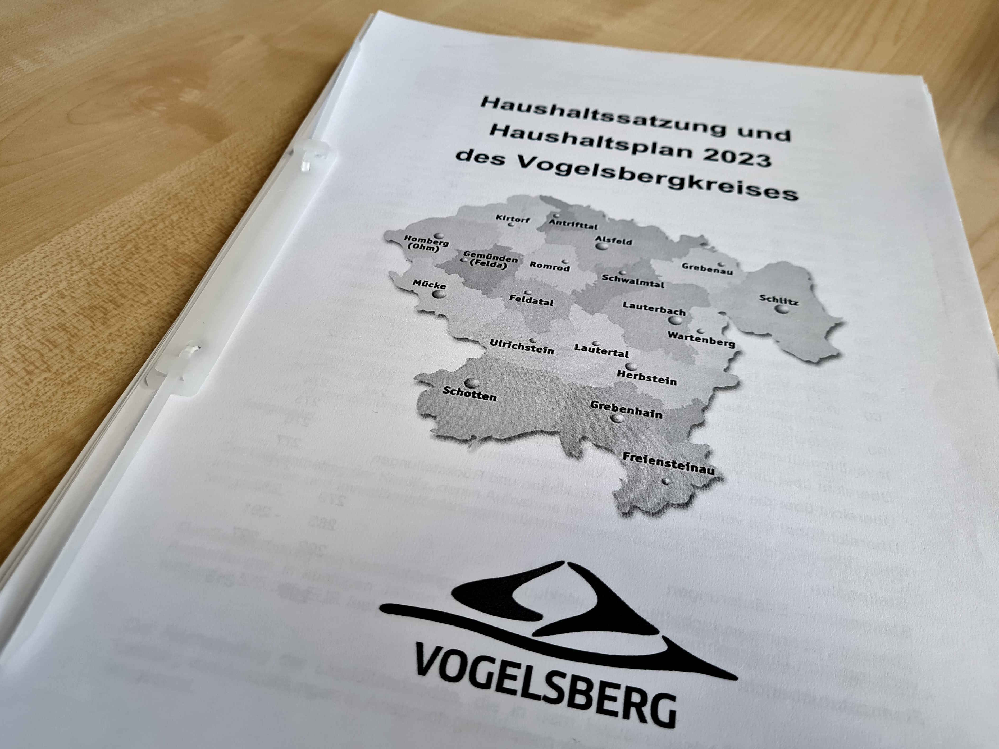 Ein mehrere hundert Seiten starker Haushaltsplan liegt auf einem Tisch. Auf dem Cover ist eine Karte des Vogelsbergkreises zu sehen.