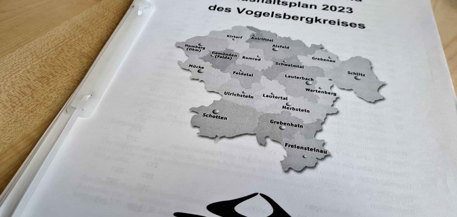 Ein mehrere hundert Seiten starker Haushaltsplan liegt auf einem Tisch. Auf dem Cover ist eine Karte des Vogelsbergkreises zu sehen.