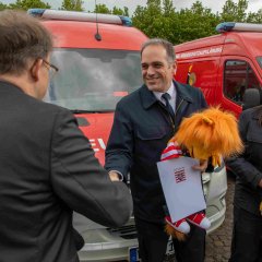Dr. Sven Holland und Heidi Schmidt bei der Übergabe des Gerätewagens Brandschutzerziehung. 