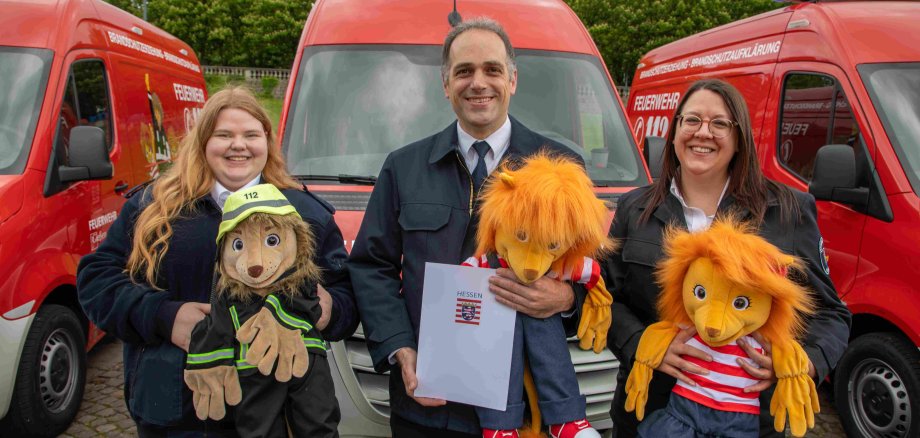 Sarah Kuhla, Dr. Sven Holland und Heidi Schmidt bei der Übergabe des Gerätewagens Brandschutzerziehung. 