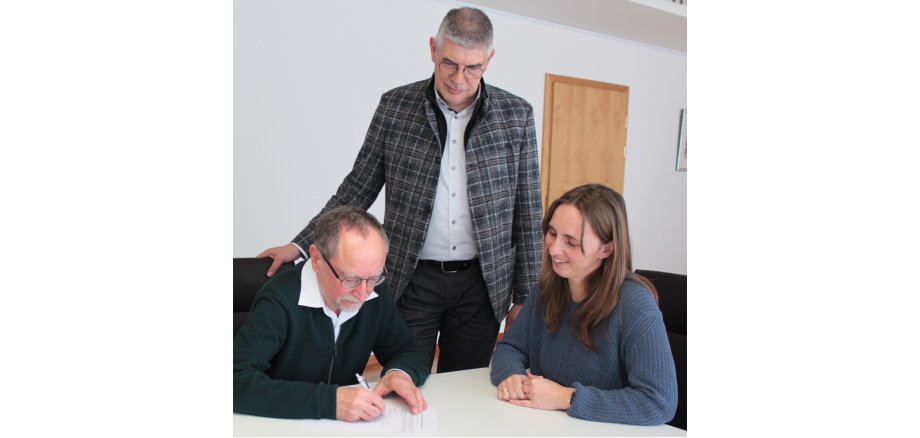 Arbeiten künftig zusammen: Hebamme Nina Decher und der Leiter des ärztlichen Rettungsdienstes, Dr. Erich Wranze-Bielefeld, unterzeichnen die Kooperation, die Landrat Manfred Görig sehr begrüßt, denn „wir erhöhen die Sicherheit im Rettungswagen“.