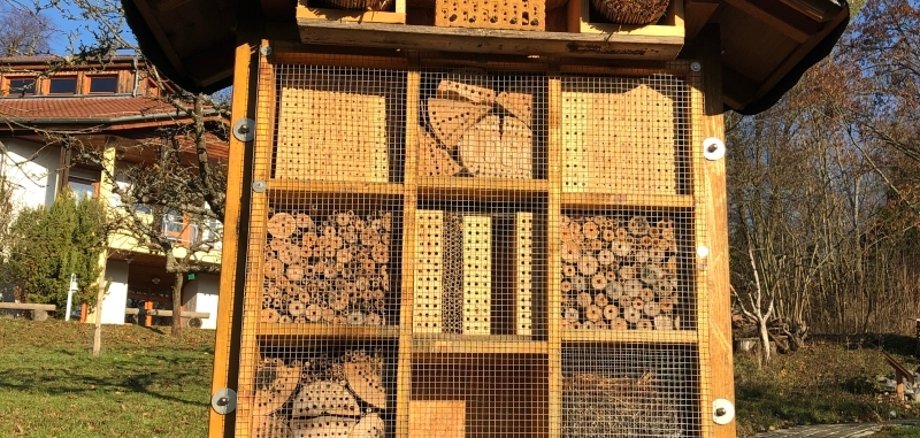 Ein Insektenhotel mit vielen Unterschlupfmöglichkeiten aus verschiedenen Materialien. Stroh, Steine, Bambus, Äste, 