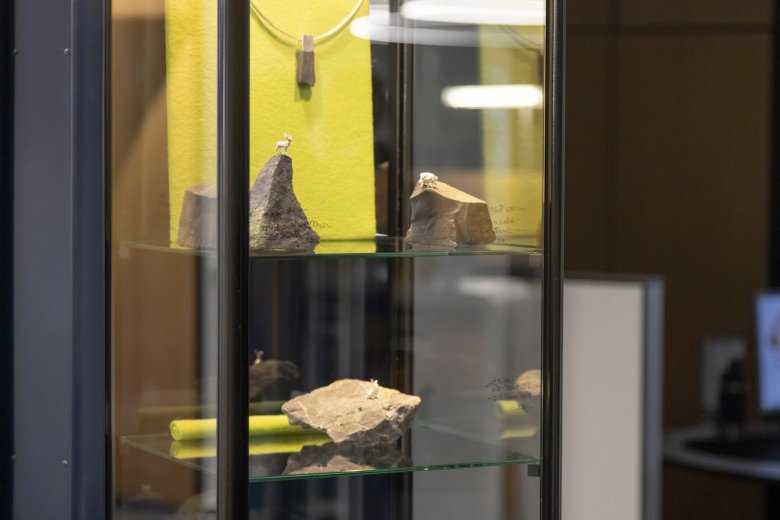Schmuckstücke auf Basaltsteinen in einer Vitrine