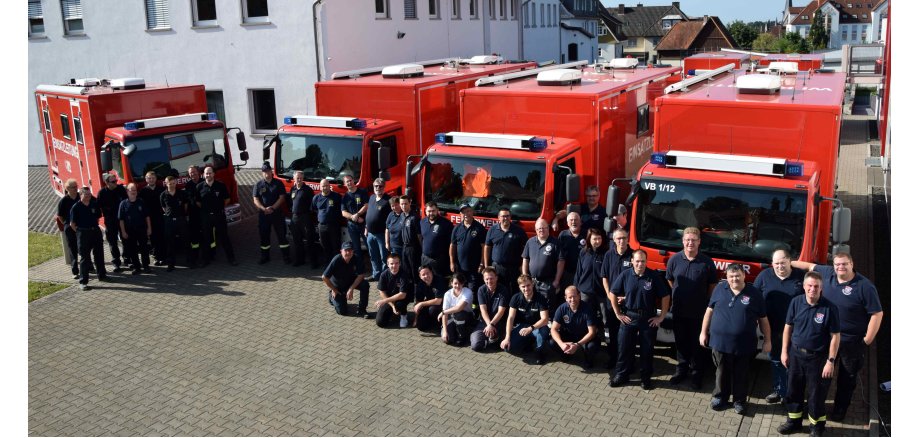 Gruppenbild der ÜbungsteilnehmerInnen vor Feuerwehrfahrzeugen