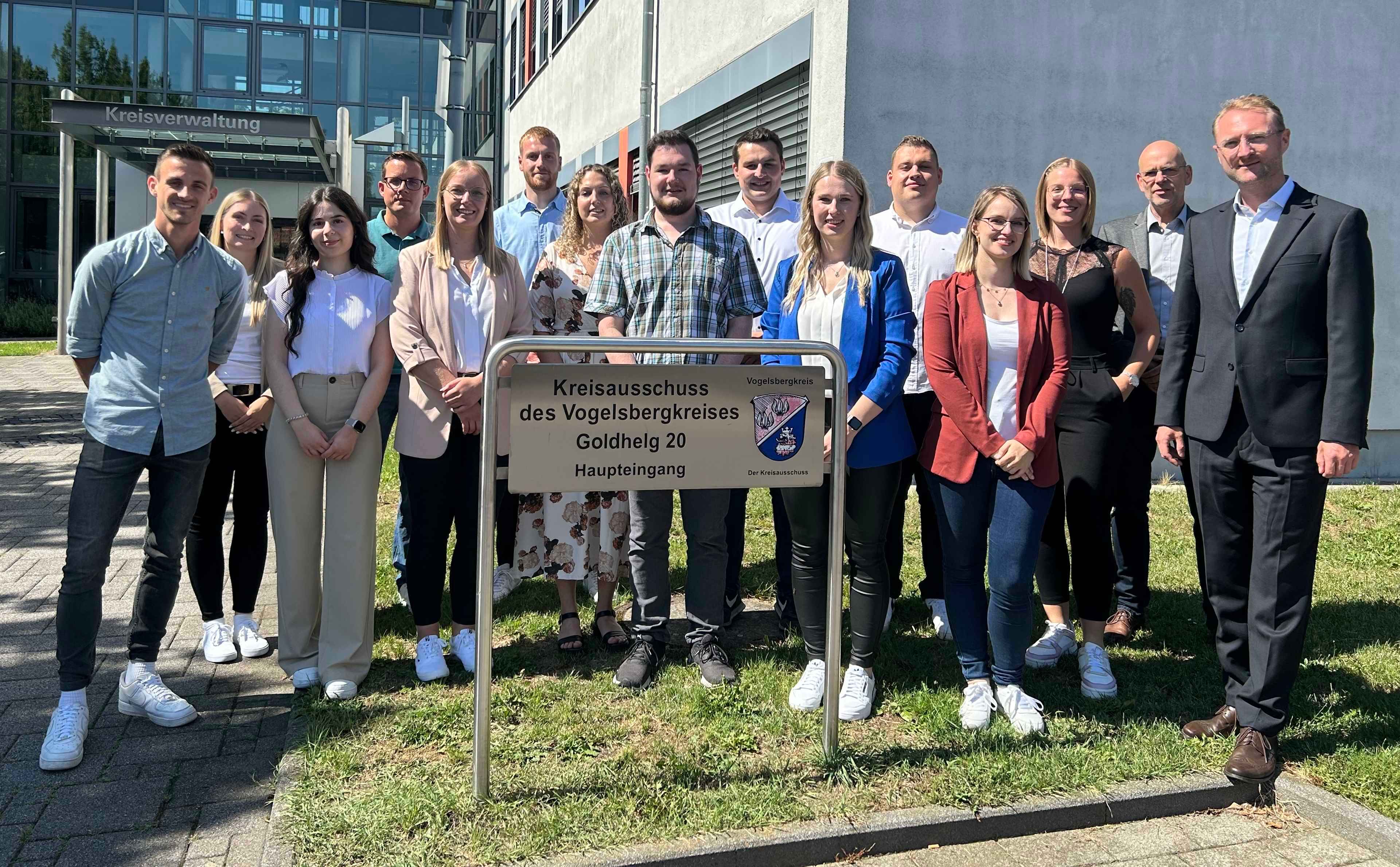 15 Menschen haben sich zu einem Gruppenbild vor der Kreisverwaltung aufgestellt.