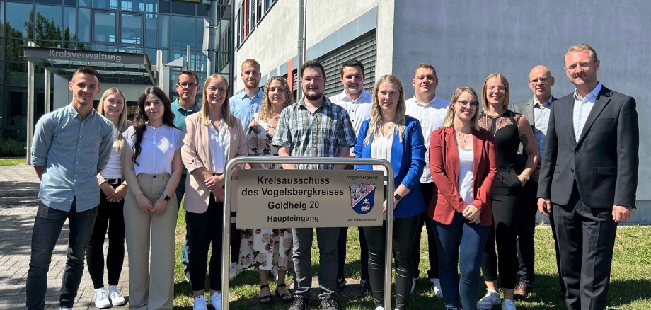 15 Menschen haben sich zu einem Gruppenbild vor der Kreisverwaltung aufgestellt.