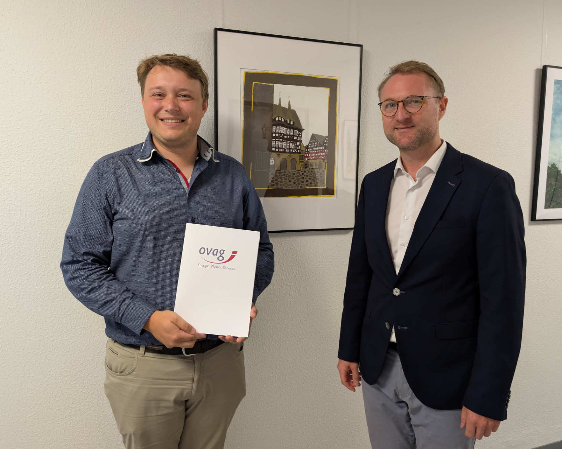 Landrat Dr. Jens Mischak (rechts), übergibt Alexander Reinsch, Stabführer der Show and Brass Band der Freiwilligen Feuerwehr der Stadt Alsfeld, eine OVAG-Spende in Höhe von 1.500 Euro. Die Spende unterstützt die Aktivitäten rund um das Jubiläum zum 75-jährigen Bestehen des Vereins.