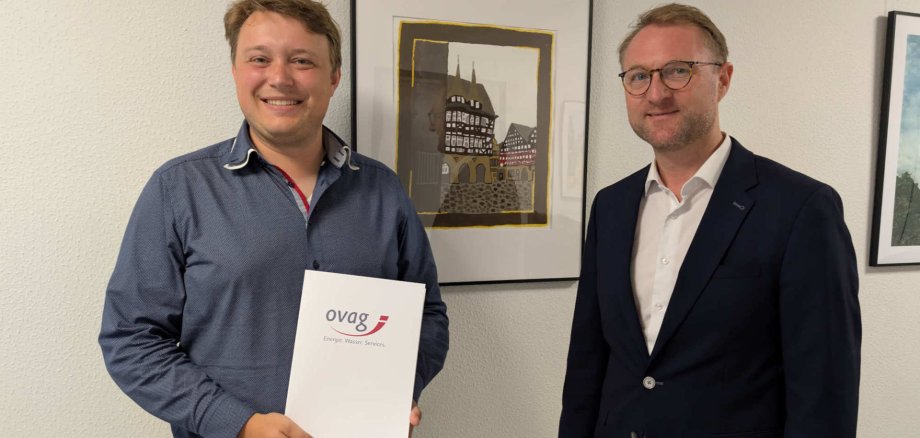 Landrat Dr. Jens Mischak (rechts), übergibt Alexander Reinsch, Stabführer der Show and Brass Band der Freiwilligen Feuerwehr der Stadt Alsfeld, eine OVAG-Spende in Höhe von 1.500 Euro. Die Spende unterstützt die Aktivitäten rund um das Jubiläum zum 75-jährigen Bestehen des Vereins.