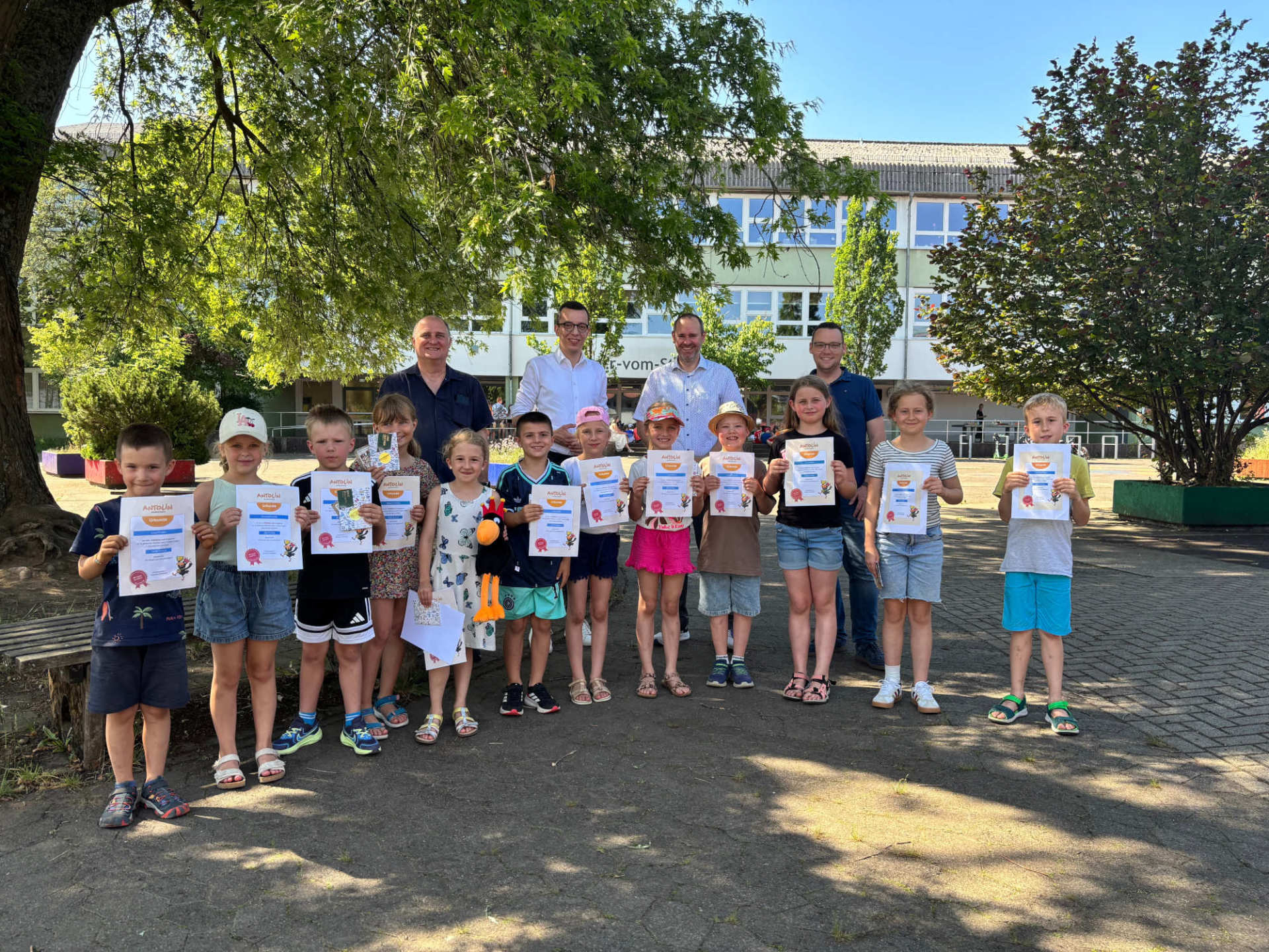 Erster Kreisbeigeordneter und Schuldezernent Patrick Krug (hinten, zweiter von links), ehrt gemeinsam mit Peter Weißmüller (hinten, von links), vom Medienzentrum Lauterbach und Koordinator des Antolin-Wettbewerbs, Dominik Günthner, Schulleiter der Grundschule, und Matthias Röse, Leiter des Amts für Schulische Bildung und Betreuung, die Klassensieger der vier Jahrgangsstufen sowie Hailey (Fünfte von links) und Tyler, die auf Kreisebene erfolgreich sind. Hailey ist Gesamtsiegerin bei den ersten Klassen, ihr Bruder Tyler Zweiter bei den Viertklässlern.