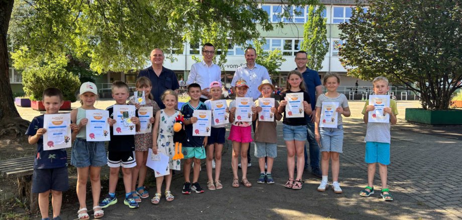 Erster Kreisbeigeordneter und Schuldezernent Patrick Krug (hinten, zweiter von links), ehrt gemeinsam mit Peter Weißmüller (hinten, von links), vom Medienzentrum Lauterbach und Koordinator des Antolin-Wettbewerbs, Dominik Günthner, Schulleiter der Grundschule, und Matthias Röse, Leiter des Amts für Schulische Bildung und Betreuung, die Klassensieger der vier Jahrgangsstufen sowie Hailey (Fünfte von links) und Tyler, die auf Kreisebene erfolgreich sind. Hailey ist Gesamtsiegerin bei den ersten Klassen, ihr Bruder Tyler Zweiter bei den Viertklässlern.