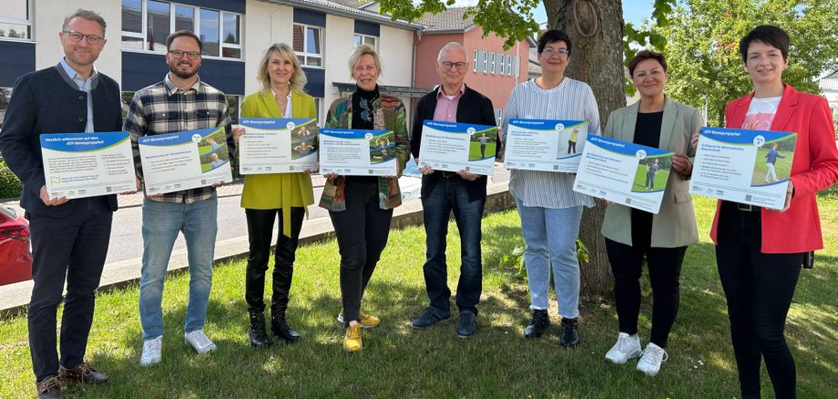 Landrat Dr. Jens Mischak und Bewegungskoordinator Dominic Günther übergeben Christiane Enders-Pfeil Familienzentrum Homberg), Gudrun Haas, Hans-Dieter Herget (Mehrgenerationenhaus Schotten), Sandra Böttner, Anja Schwalm (Mehrgenerationenhaus Romrod) und Hombergs Bürgermeisterin Simke Ried (von links) die ATP-Schilder, die mehr Bewegung in die Kommunen bringen sollen.