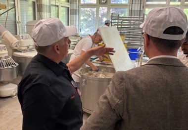Vulkanbäckermeister Haas erläutert die Abläufe in der Backstube, wo täglich bis zu 40.000 Teile produziert werden.