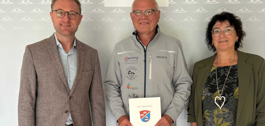Landrat Dr. Jens Mischak und Anke Koch, zuständig für die Sportförderung in der Vogelsberger Kreisverwaltung, überreichen Ulrich Fritzges den Bewilligungsbescheid.