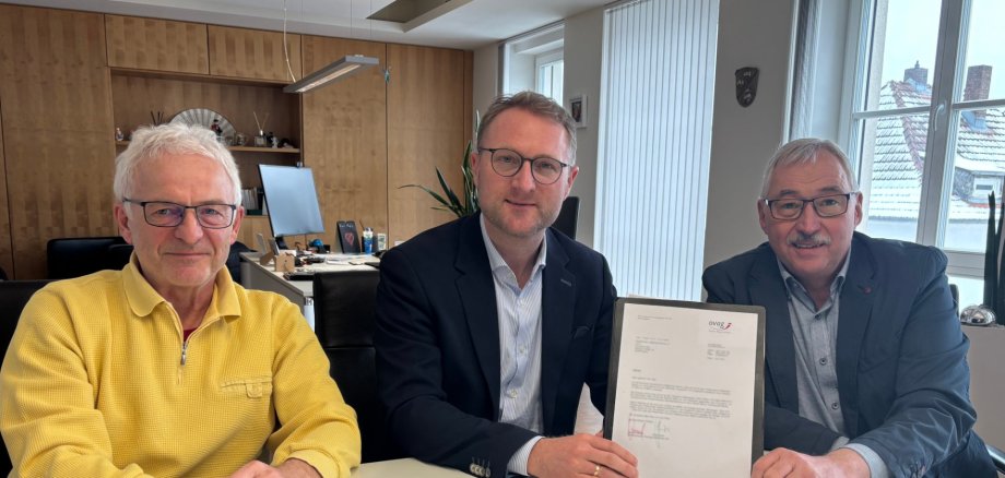 Landrat Dr. Jens Mischak übergibt Holger Seng (rechts), 2. Vorsitzender vom Förderverein Hallenbad Mücke, und Lothar Schellhaas (links), Aufsichtsratsmitglied der Bürgergenossenschaft Hallenbad Mücke, eine Ovag-Spende in Höhe von 5000 Euro.