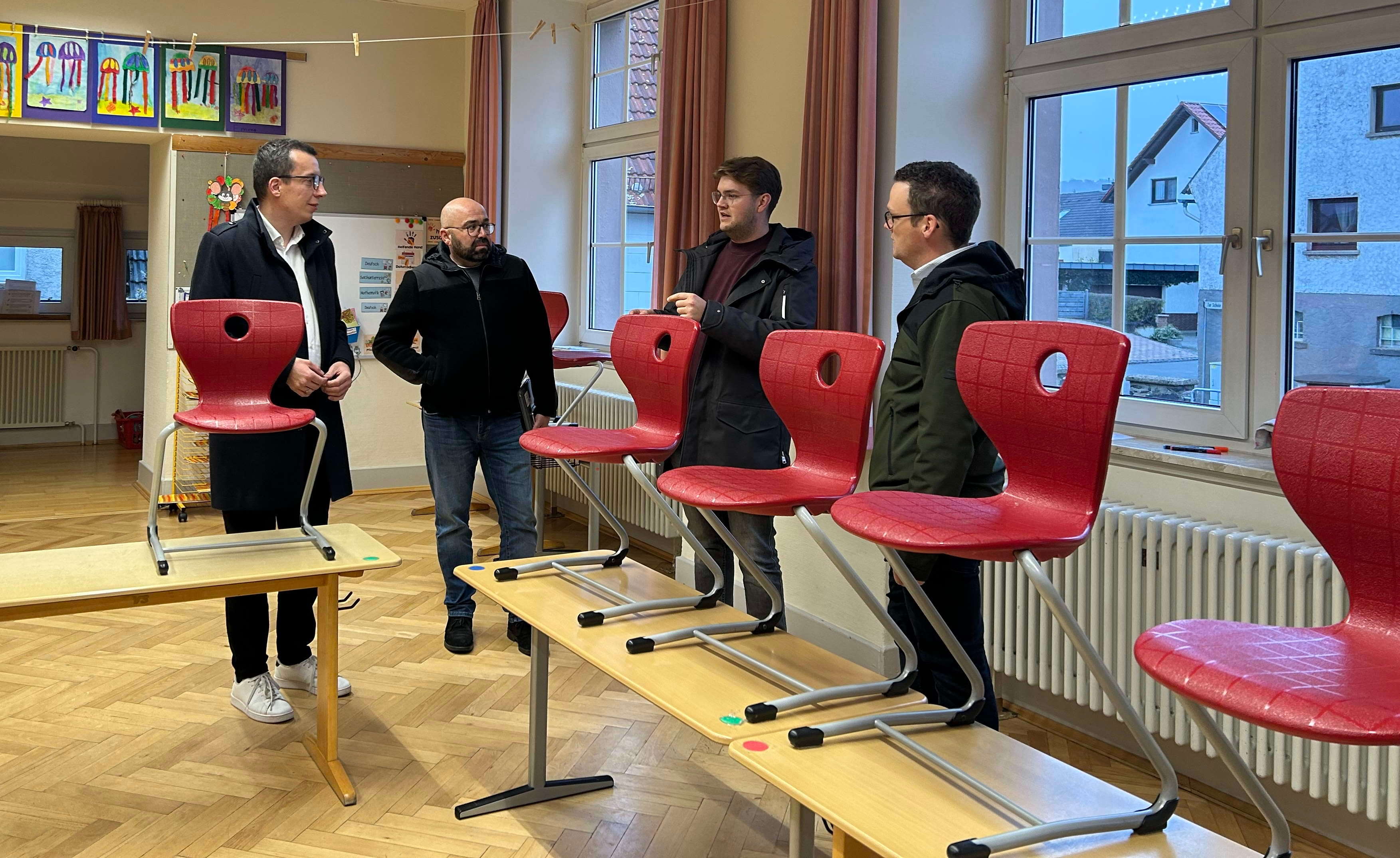 Erster Kreisbeigeordneter Patrick Krug schaut sich gemeinsam mit Stefan Schmidt, dem Leiter des Amtes für Hochbau, Energie und Gebäudewirtschaft, Schulleiter Lukas Alt und Matthias Röse, dem Leiter des Amtes für Schulische Bildung und Betreuung (von links) den Schulstandort in Storndorf an.