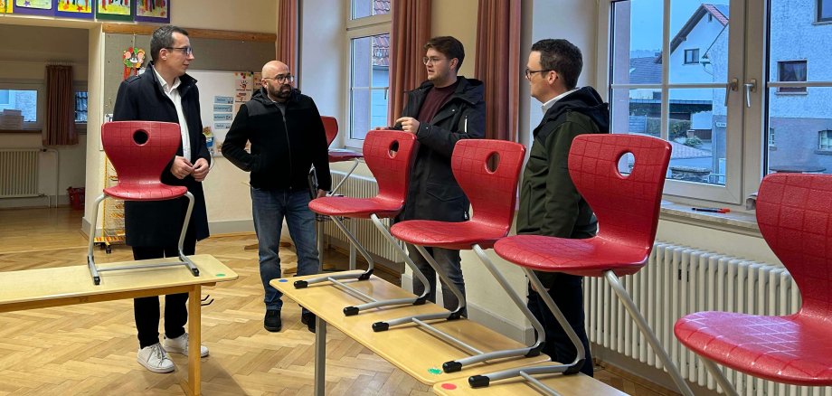 Erster Kreisbeigeordneter Patrick Krug schaut sich gemeinsam mit Stefan Schmidt, dem Leiter des Amtes für Hochbau, Energie und Gebäudewirtschaft, Schulleiter Lukas Alt und Matthias Röse, dem Leiter des Amtes für Schulische Bildung und Betreuung (von links) den Schulstandort in Storndorf an.