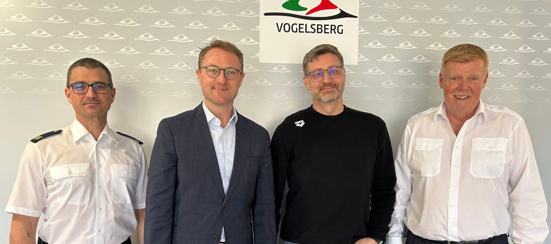 Landrat Dr. Jens Mischak, Kreisbrandinspektor Marcell Büttner und Jürgen Schad, stellvertretender Leiter des Amtes für Gefahrenabwehr, begrüßen mit Daniel Pree (Zweiter von rechts) einen weiteren Ärztlichen Leiter im Rettungsdienst.