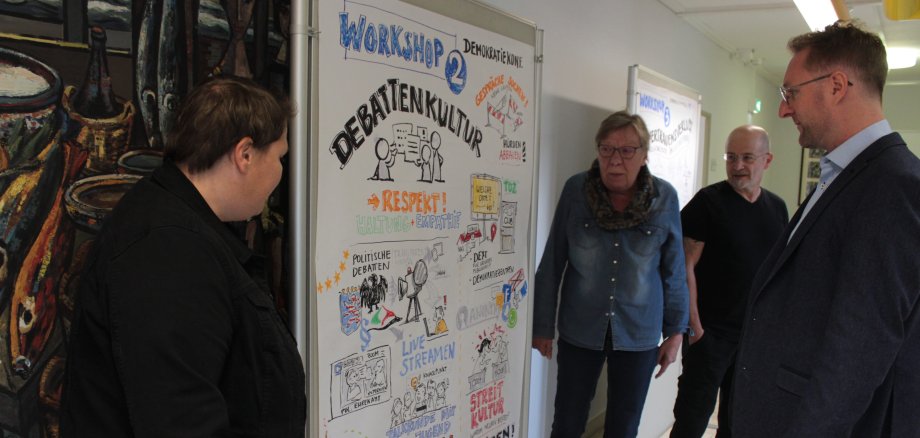 Noch bis zum 28. Oktober sind Grafiken, die im Rahmen der Demokratiekonferenz entstanden im Landratsamt ausgestellt. Am Freitag nahm Erster Kreisbeigeordneter Dr. Jens Mischak gemeinsam mit (von links) Maria Hoyer (Demokratie leben Alsfeld), Silvia Lucas (Demokratie leben Vogelsbergkreis) und Thomas Luft (Demokratie leben Alsfeld) die Arbeiten in Augenschein. 