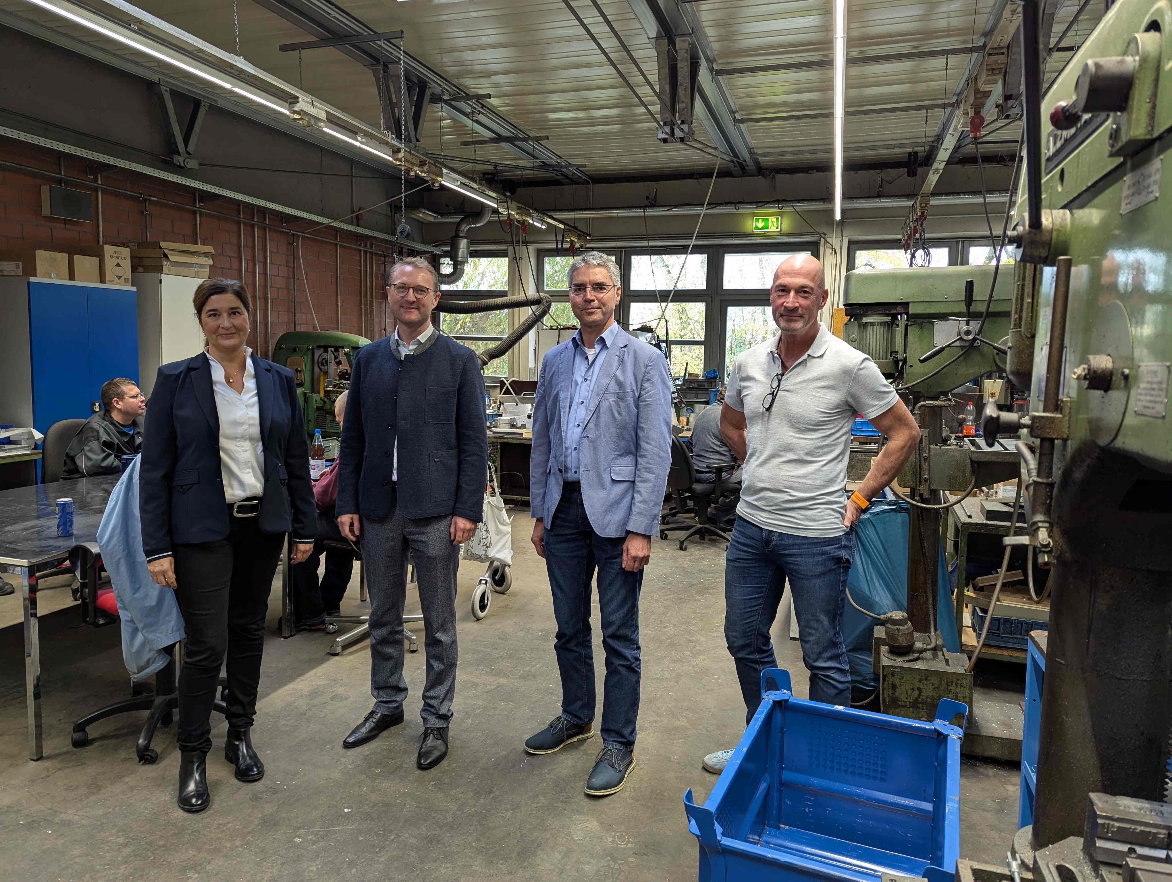 Landrat Dr. Jens Mischak (Zweiter von rechts) gemeinsam Katja Diehl (von links), Vorstandsvorsitzende, Frank Haberzettl, Vorstand und zuständig für den Fachbereich Arbeit und Bildung, und Michael Dippel, Werkstattleiter in Alsfeld, beim gemeinsamen Rundgang in der Metallwerkstatt. (Foto: Vogelsbergkreis/C.Lips)