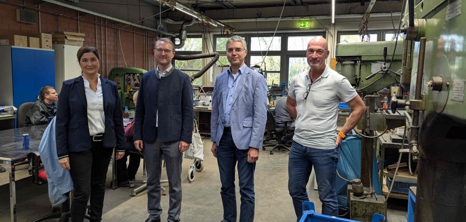 Landrat Dr. Jens Mischak (Zweiter von rechts) gemeinsam Katja Diehl (von links), Vorstandsvorsitzende, Frank Haberzettl, Vorstand und zuständig für den Fachbereich Arbeit und Bildung, und Michael Dippel, Werkstattleiter in Alsfeld, beim gemeinsamen Rundgang in der Metallwerkstatt. (Foto: Vogelsbergkreis/C.Lips)