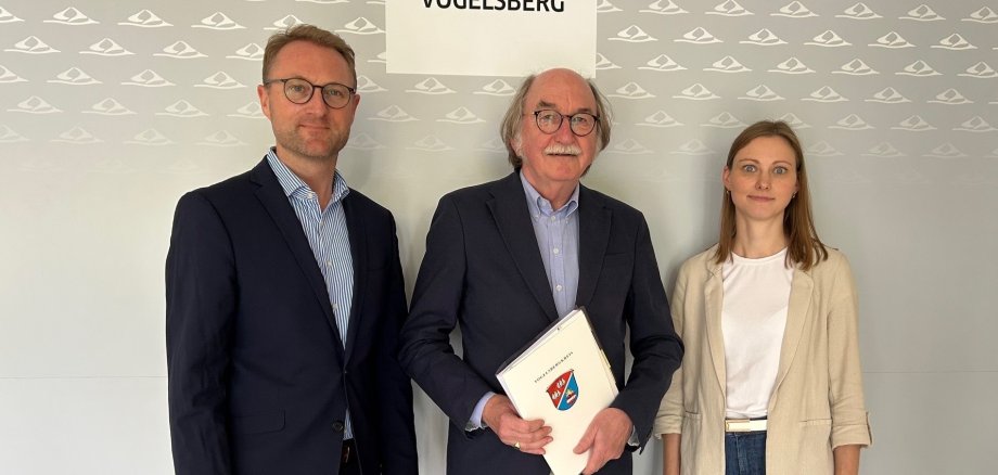 Landrat Dr. Jens Mischak und Jana Brittner, die Leiterin des Sachgebiets Dorf- und Regionalentwicklung, überreichen Lauterbachs Bürgermeister Rainer-Hans Vollmöller die Förderbescheide.