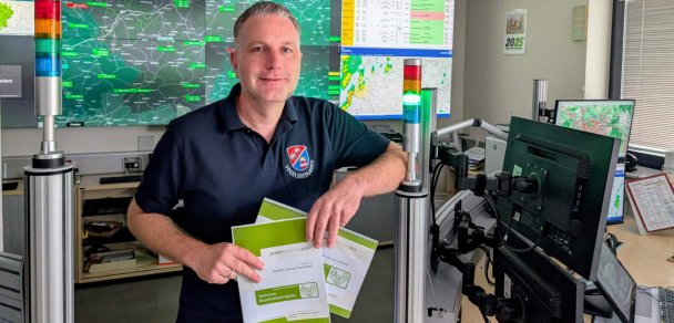 Dr. Dennis Humburg, ärztlicher Leiter des Rettungsdiensts im Vogelsbergkreis, präsentiert die Daten des Reanimations-Register für den Vogelsbergkreis. Er steht vor einer Videowand, an der Rettungsdienstinformationen und KArten zu sehen sind.