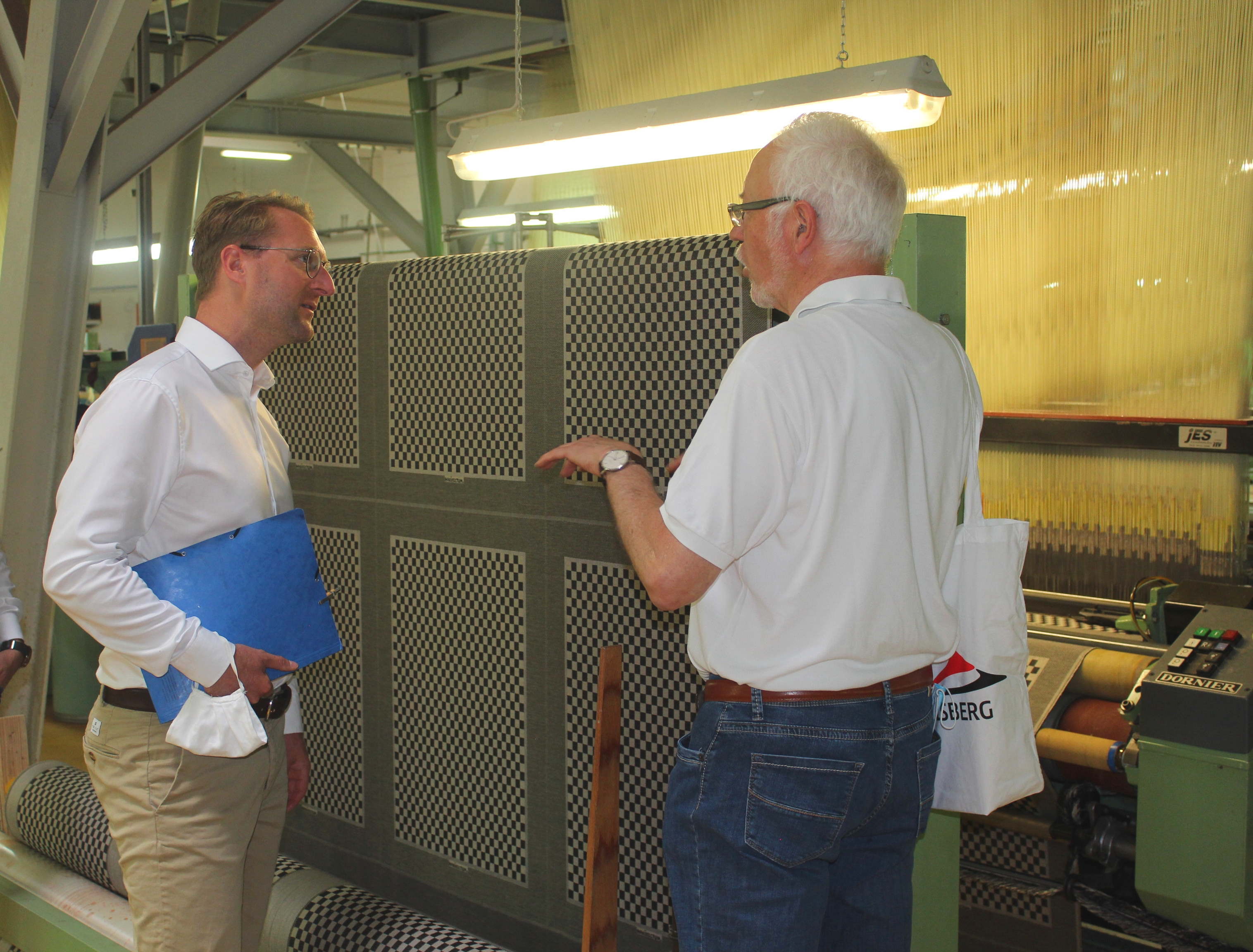 Im Gespräch: Wirtschaftsdezernent Dr. Jens Mischak (links) lässt sich von Helmut Driessen, Geschäftsführer der Schlitzer Leinen-Industrie Driessen eine der großen Maschinen in der Weberei erklären. 
