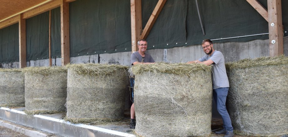 Claudia und Hartmut Eifert (links) haben ihren Bioland-Betrieb in Lautertal-Hörgenau auf Heumilch-Produktion umgestellt. Bei mehr als 1000 Ballen im Jahr braucht es viel Planung – die Heutrocknung erleichtert die Abläufe. Mario Hanisch, Projektkoordinator Ökomodell-Region Vogelsberg, arbeitet im Rahmen der Initiative Bio-Heumilch Rhön-Vogelsberg eng mit dem Betrieb zusammen. 