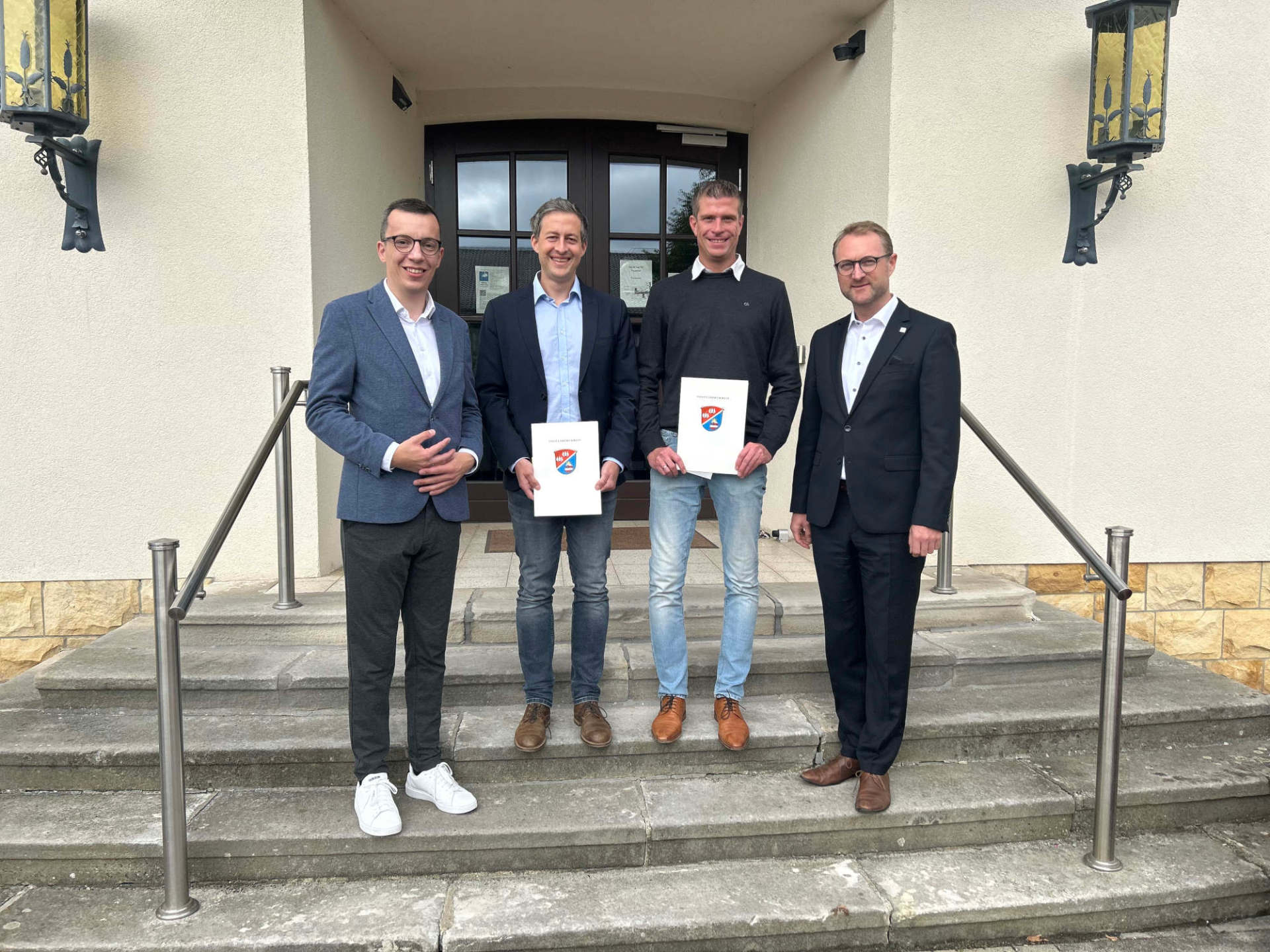 Landrat Dr. Jens Mischak (rechts) gratuliert gemeinsam mit Erstem Kreisbeigeordneten Patrick Krug (links) Tobias Lippert (von links) und Stefan Jost zum 25-jährigen Dienstjubiläum. 