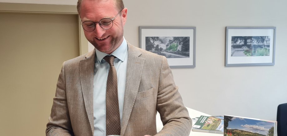 Erster Kreisbeigeordneter Dr. Mischak liest in der Broschüre