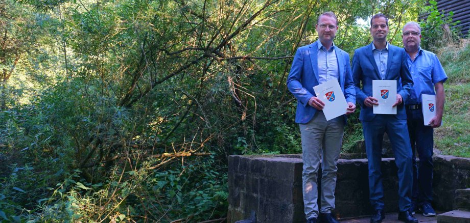 Dr. Jens Mischak, Erster Kreisbeigeordneter, übergibt am Pfingstborn in Hutzdorf drei Zuwendungsbescheide an Bürgermeister Heiko Siemon und Martin Wedler, Fachbereichsleiter Technische Dienste der Stadt Schlitz.