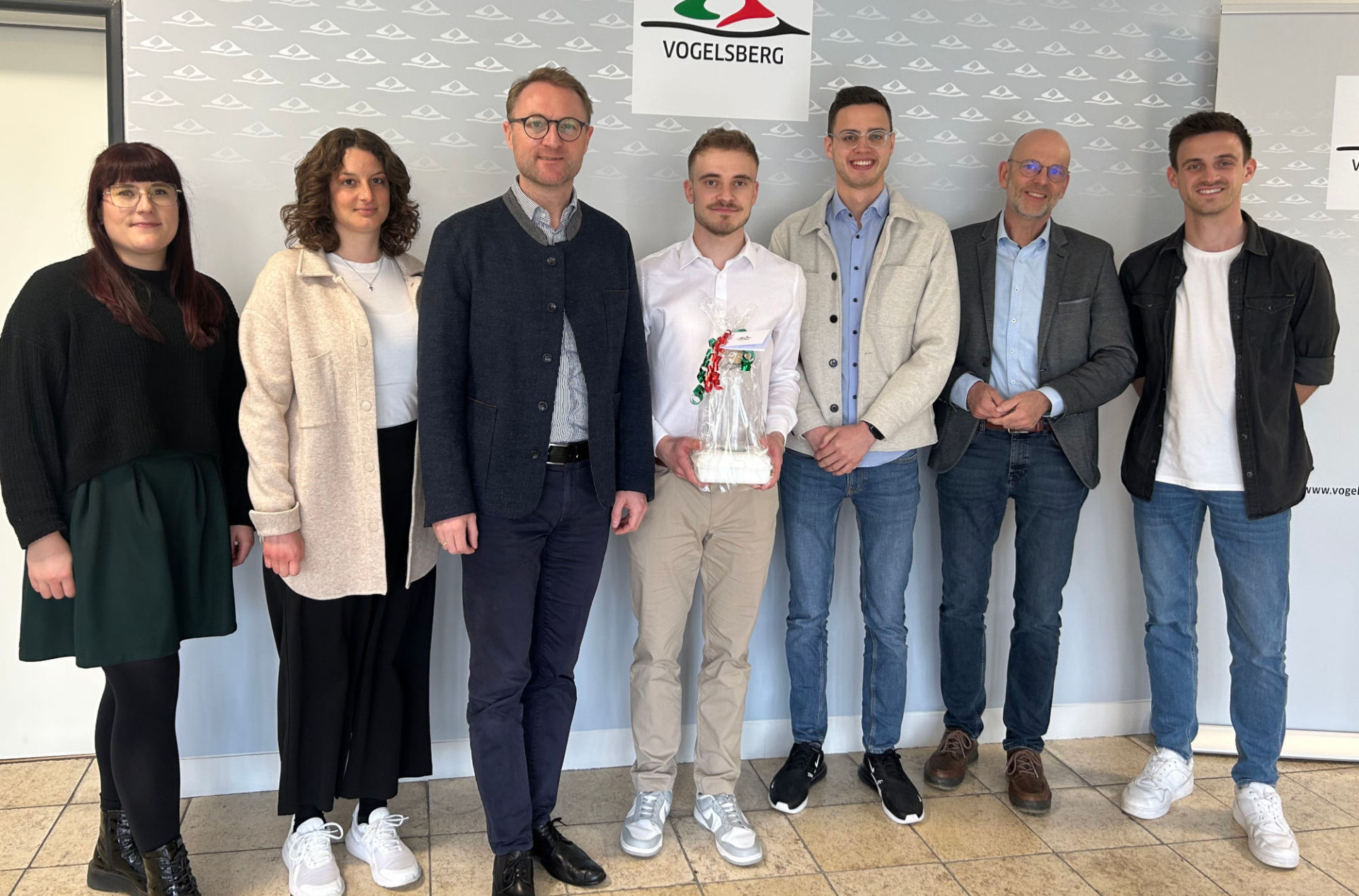 Hervorragende Leistung: Elias Christen (Mitte) hat sein BASS-Studium erfolgreich abgeschlossen und nimmt die Glückwünsche von Landrat Dr. Jens Mischak (Dritter von links), Hauptamtsleiter Ulrich Schäfer (Zweiter von rechts), Ausbildungsleiter Timo Walper (rechts), seinem Fachdienstleiter bei der KVA, Florian Steuernagel (Dritter von rechts), der Ausbildungsleiterin der BASS-Studenten, Lisa Schlitt (Zweite von links) und der Gleichstellungsbeauftragten Antonia Schäfer entgegen.