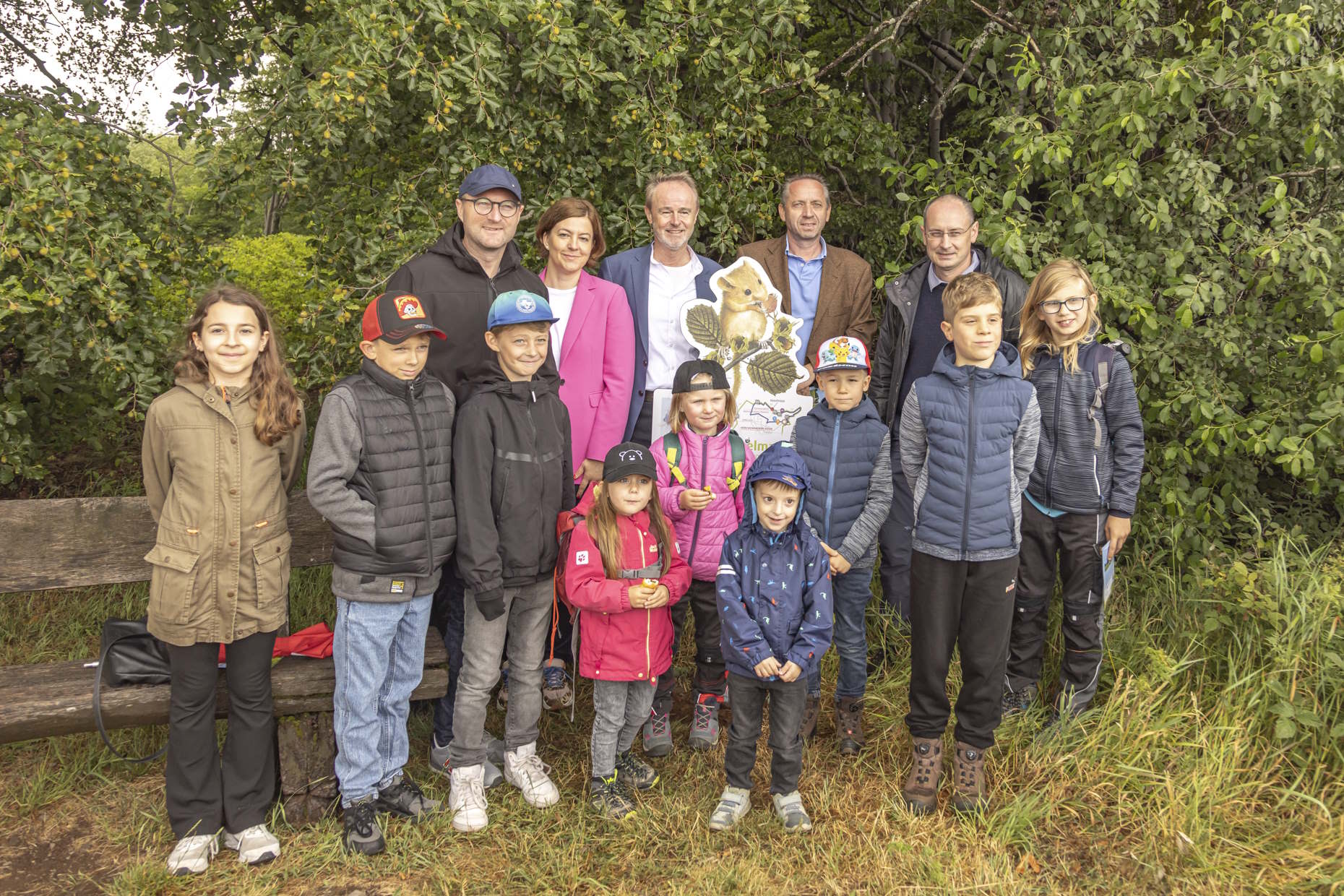 Dr. Jens Mischak (hinten, von links), Erster Kreisbeigeordneter, Andrea Kuhn (Hassia Mineralquellen), Jürgen Scheider (REWE Mitte), Günter Berz-List (Schwälbchen Molkerei), Sebastian Stang (Bürgermeister Gemeinde Grebenhain) und Kinder am neuen Familien-Pfad auf der Herchenhainer Höhe.