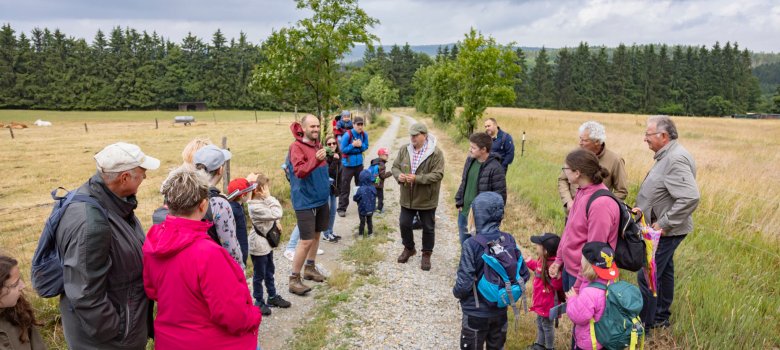 Die Mitarbeiter des Naturschutzgroßprojekts und des Amtes für Wirtschaft und den ländlichen Raum informierten auf dem Familienweg. Sie stehen auf einem Feldweg inmitten einer Gruppe von Menschen