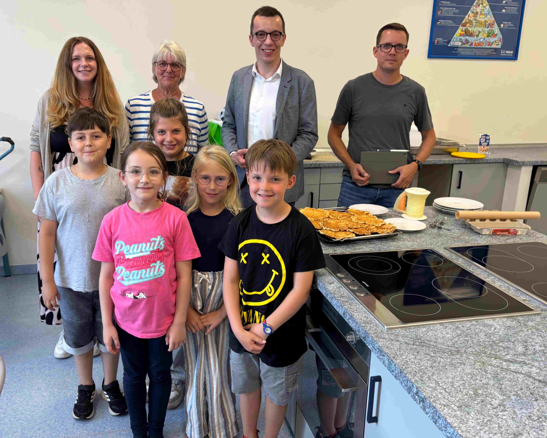Erster Kreisbeigeordneter und Schuldezernent Patrick Krug (zweiter von rechts) besucht gemeinsam mit Florian Eurich (rechts), stellvertretender Leiter des Amts für Schulische Bildung und Betreuung, die Ferienbetreuung an der Grundschule Feldatal. Dort werden die beiden von Denise Steuernagel-Mahr (hinten, von links) und Martina Seibert vom Betreuungsteam sowie von David, Thea, Emma, Clara und Maximilian empfangen.