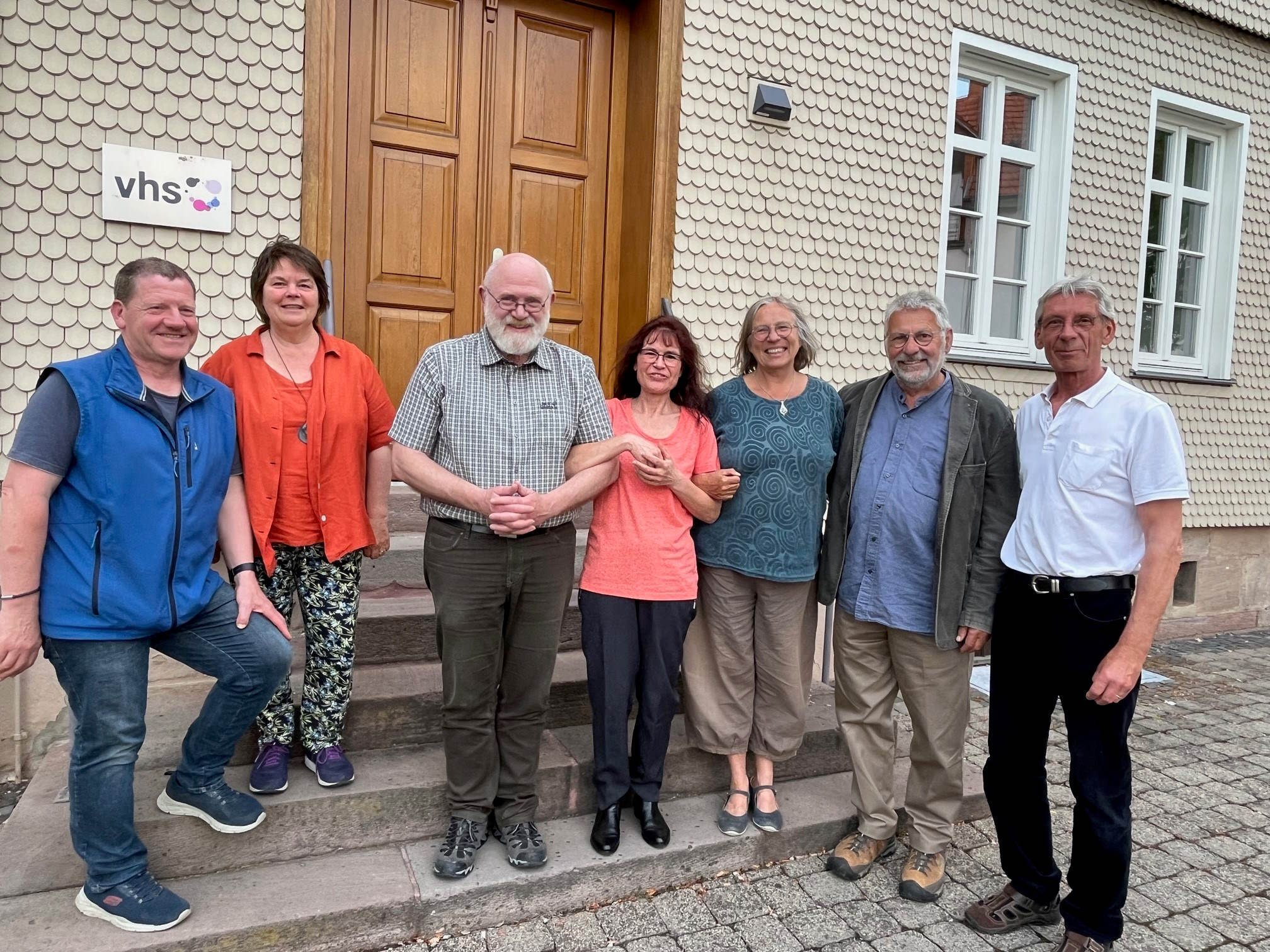 Kursleiter Dr. Martin Jatho mit Teilnehmern des Klima.fit-Kurses. Sie haben sich für ein Gruppenbild auf einer Sandsteintreppe aufgestellt. 