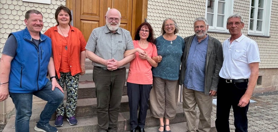 Kursleiter Dr. Martin Jatho mit Teilnehmern des Klima.fit-Kurses. Sie haben sich für ein Gruppenbild auf einer Sandsteintreppe aufgestellt. 