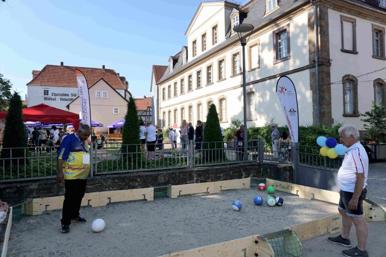 Ein Sportler aus Curacao spielt Fußballbillard mit bunten Fußbällen in einem begrenzten Spielfeld