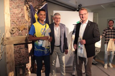Landrat Görig und Dr. Mischak gemeinsam mit einem Sportler aus Curacao
