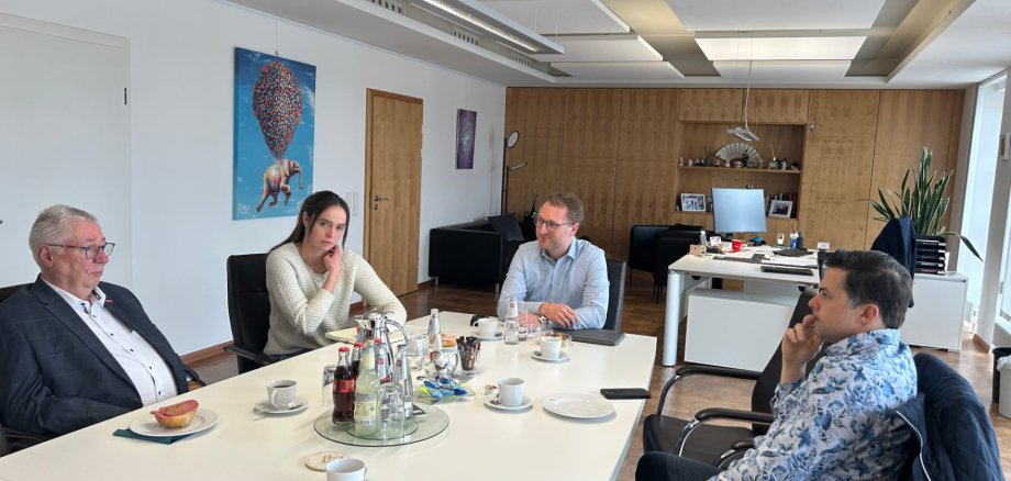 Landrat Dr. Jens Mischak und Kathrin Janisch von der Wirtschaftsförderung des Kreises im Gespräch mit Kreishandwerksmeister Edwin Giese (links) und Torsten Schneider (rechts), dem Vorsitzenden des IHK-Regionalausschusses. Sie sitzen an einem Konferenztisch und sind im Gespräch