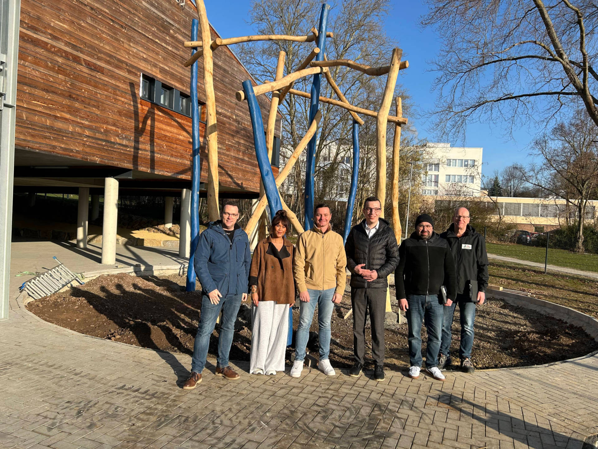 Erster Kreisbeigeordneter Patrick Krug (Dritter von rechts) nimmt gemeinsam mit Jürgen Henke und Stefan Schmidt vom Amt für Hochbau, Energie und Gebäudewirtschaft, Schulleiter Angelo Müller, Narnemon Lehmann von der Betreuung und Matthias Röse vom Amt für Schulische Bildung und Betreuung (von rechts) das neu gestaltete Außengelände der Gerhart-Hauptmann-Schule in Augenschein. Das Kletternest im Hintergrund war am Donnerstag installiert worden.Erster Kreisbeigeordneter Patrick Krug (Dritter von rechts) nimmt gemeinsam mit Jürgen Henke und Stefan Schmidt vom Amt für Hochbau, Energie und Gebäudewirtschaft, Schulleiter Angelo Müller, Narnemon Lehmann von der Betreuung und Matthias Röse vom Amt für Schulische Bildung und Betreuung (von rechts) das neu gestaltete Außengelände der Gerhart-Hauptmann-Schule in Augenschein. Das Kletternest im Hintergrund war am Donnerstag installiert worden.