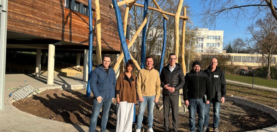 Erster Kreisbeigeordneter Patrick Krug (Dritter von rechts) nimmt gemeinsam mit Jürgen Henke und Stefan Schmidt vom Amt für Hochbau, Energie und Gebäudewirtschaft, Schulleiter Angelo Müller, Narnemon Lehmann von der Betreuung und Matthias Röse vom Amt für Schulische Bildung und Betreuung (von rechts) das neu gestaltete Außengelände der Gerhart-Hauptmann-Schule in Augenschein. Das Kletternest im Hintergrund war am Donnerstag installiert worden.Erster Kreisbeigeordneter Patrick Krug (Dritter von rechts) nimmt gemeinsam mit Jürgen Henke und Stefan Schmidt vom Amt für Hochbau, Energie und Gebäudewirtschaft, Schulleiter Angelo Müller, Narnemon Lehmann von der Betreuung und Matthias Röse vom Amt für Schulische Bildung und Betreuung (von rechts) das neu gestaltete Außengelände der Gerhart-Hauptmann-Schule in Augenschein. Das Kletternest im Hintergrund war am Donnerstag installiert worden.
