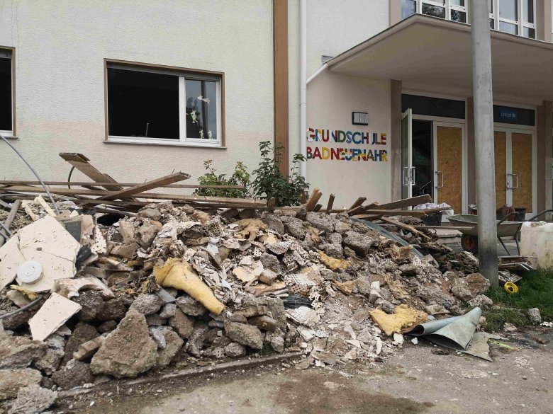 Foto eines verwüsteten Eingangs der Grundschule in Bad Neuenahr. Es liegen viele Trümmer und Bauschutt verstreut. Das Hochwasser hat viele Schäden angerichtet.